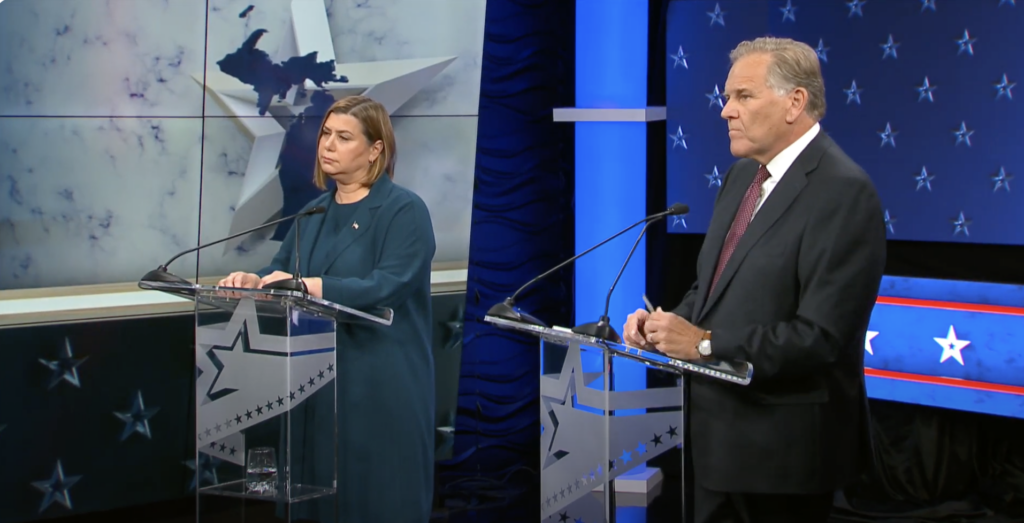 Slotkin and Rogers at debate podiums.